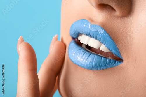 Beautiful young woman with unusual makeup on color background, closeup