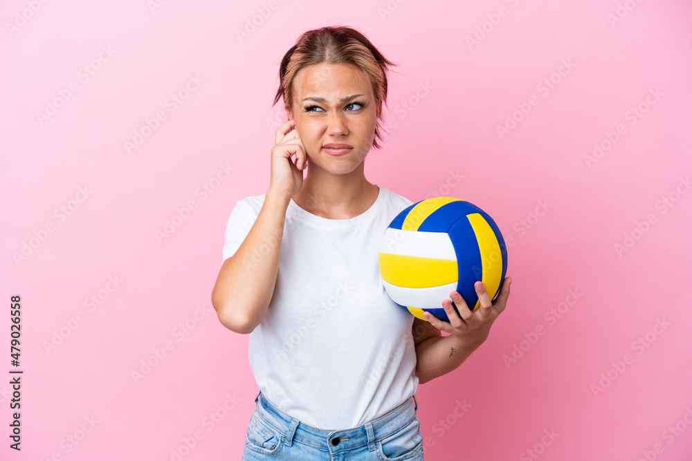 Young Russian woman playing volleyball isolated on pink background frustrated and covering ears Young Russian woman playing volleyball isolated on pink background frustrated and covering ears