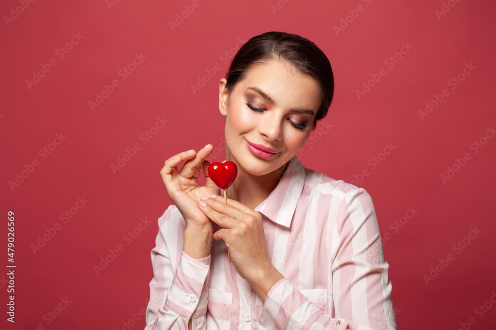 Cheerful smiling woman with heart shape on red Cheerful smiling woman with heart shape on red