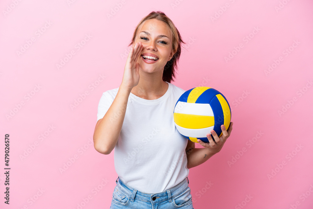 Young Russian woman playing volleyball isolated on pink background shouting with mouth wide open