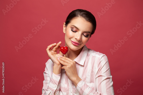 Cheerful smiling woman with heart shape on red