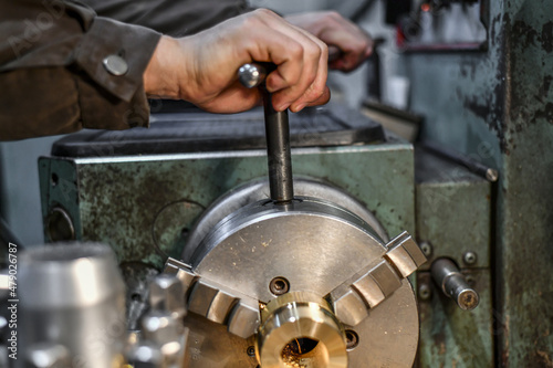 Tableau sur toile The work turner clamps the bronze parts in the jaws of the lathe chuck