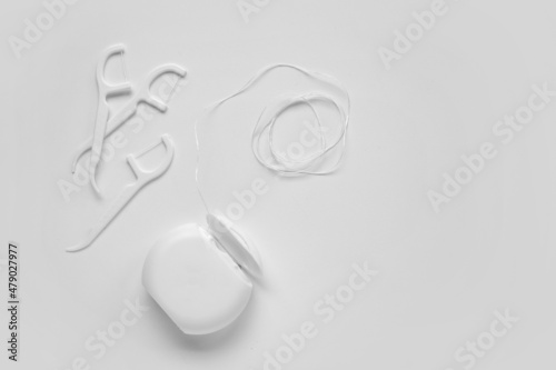 Dental floss and toothpicks on white background