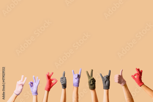 Women in warm gloves showing different gestures on beige background