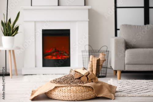 Firewood with pellets on pouf in living room photo