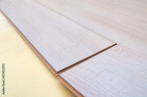 connection of two laminated floor boards on a yellow base close-up