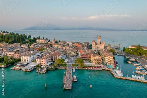 Aerial panoramic view of Sirmione city old town on lake Garda in Lombardy, Italy. Evening photo with a castle in a center