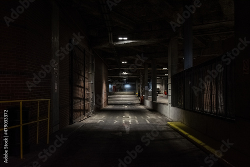 Underground parking scene - Gloomy industrial scene - modern painted handrails - old concrete and brick structure - vehicle loading bay