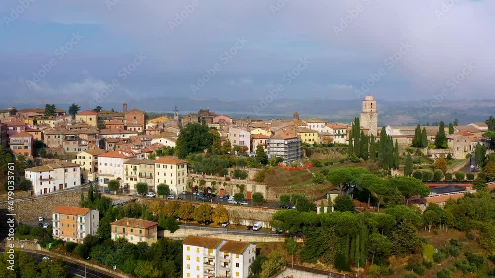 Chiusi village cityscape in Tuscany Italy with orange red rooftop tile houses on mountain countryside and rolling hills. Colorful evening in small town of Chiusi, Tuscany Italy. Chiusi village cityscape in Tuscany Italy with orange red rooftop tile houses on mountain countryside and rolling hills. Colorful evening in small town of Chiusi, Tuscany Italy.