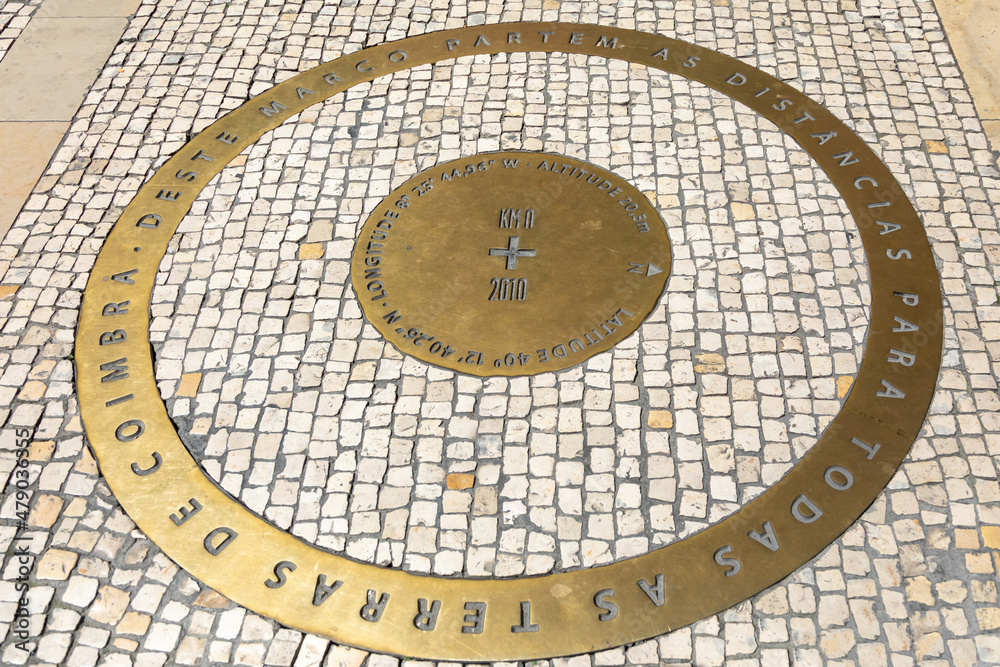 Latitude and Longitude marker on a traditional Portuguese sidewalk. Kilometer zero point or Zero mile marker. Inscription: The distances to all the lands of Coimbra start from this landmark.