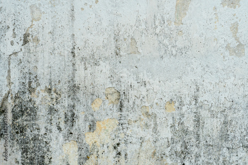 The surface of a concrete wall with old peeling paint. The texture of time-damaged paint. Multi-colored blank background for the design.