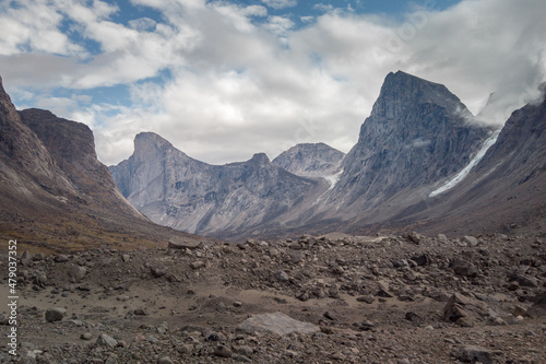 Southwest face of Mt. Thor, highest vertical cliff on Earth, on a day of arctic summer. HIking in wild, remote arctic valley of Akshayuk Pass, Baffin Island, Canada.