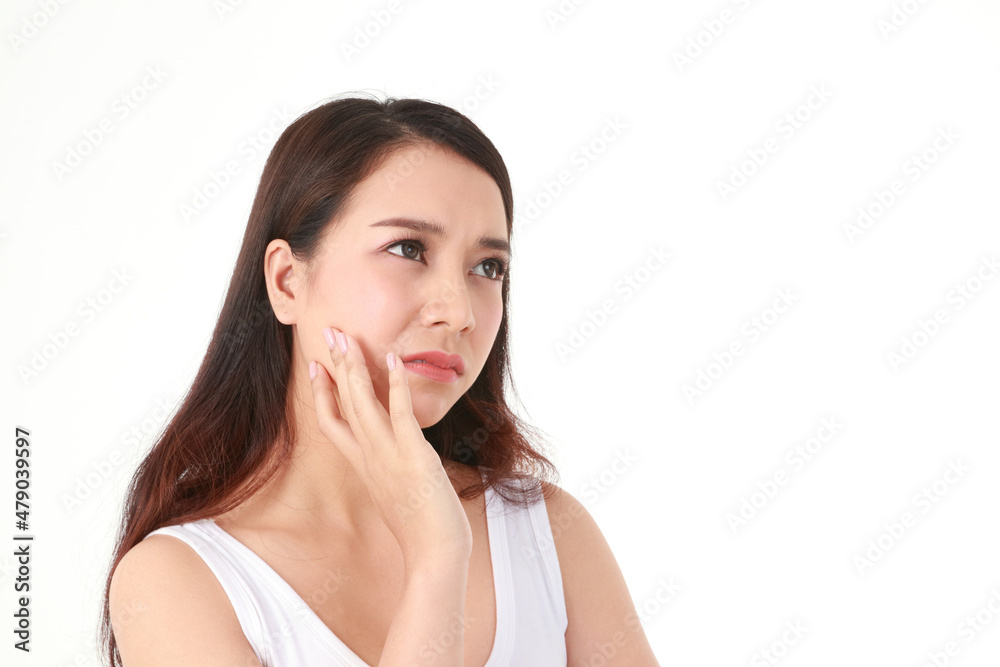 A beautiful Asian woman with long hair is stressed and worried about her facial skin problems. Beauty concept. Beautiful skin care. Acne treatment. White background. A beautiful Asian woman with long hair is stressed and worried about her facial skin problems. Beauty concept. Beautiful skin care. Acne treatment. White background.