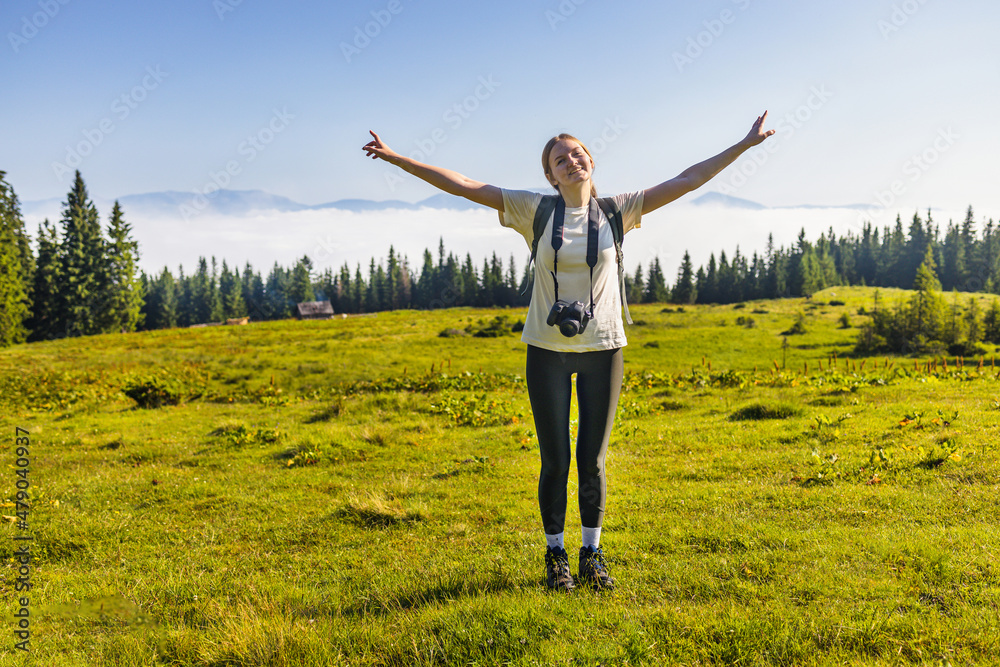 Traveler photographer with a camera alone view hands raised over clouds in the nature. Amazing Carpathians landscape background banner panorama Traveler photographer with a camera alone view hands raised over clouds in the nature. Amazing Carpathians landscape background banner panorama