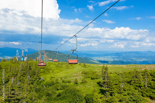 Cable car in motion in mountain top against cloudy blue sky. Sport and active life