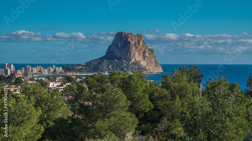 Peñón de Ifach desde Morro de Toix entre pinos viendo su cara oeste junto al puerto deportivo y pesquero photo