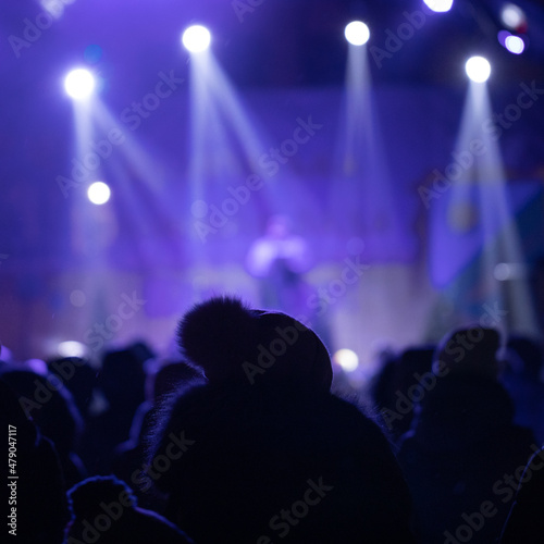 Many people at a night concert. Selective focus.