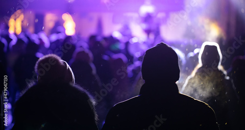 Many people at a night concert. Selective focus.