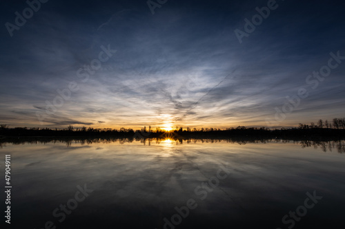 Beautiful sunset landscape sunset on the lake  reflected on the calm water - France