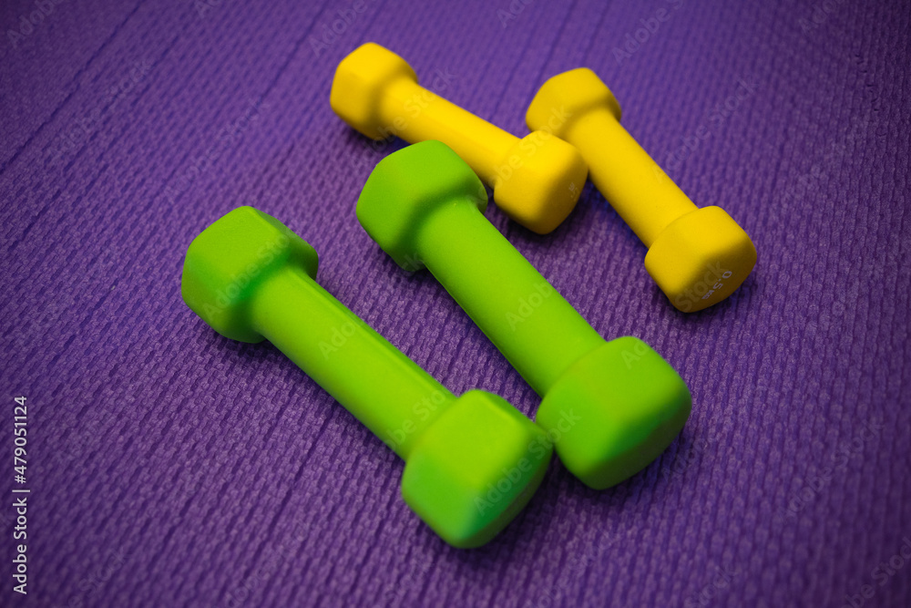 Dumbbells for sports on a soft mat in the gym. Dumbbells for sports on a soft mat in the gym.