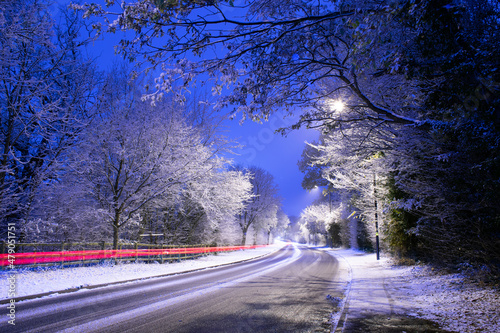 Light trails on night winter snowy road in England