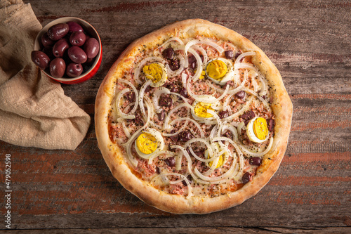 Tasty Portuguese pizza on rustic wooden background. Top view.