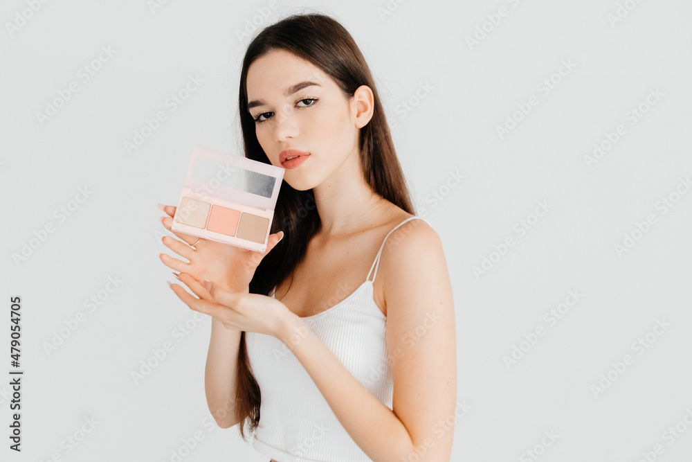 Portrait of sensual girl holding contouring palette with bronzer, highlighter and a blush, wanting to make perfect impression, isolated over white color background Portrait of sensual girl holding contouring palette with bronzer, highlighter and a blush, wanting to make perfect impression, isolated over white color background