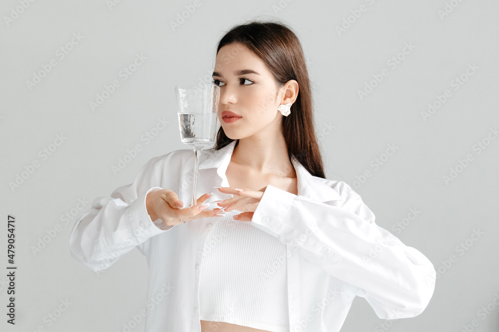Young smiling woman holding glass of water, studio portrait on white. Young smiling woman holding glass of water, studio portrait on white.