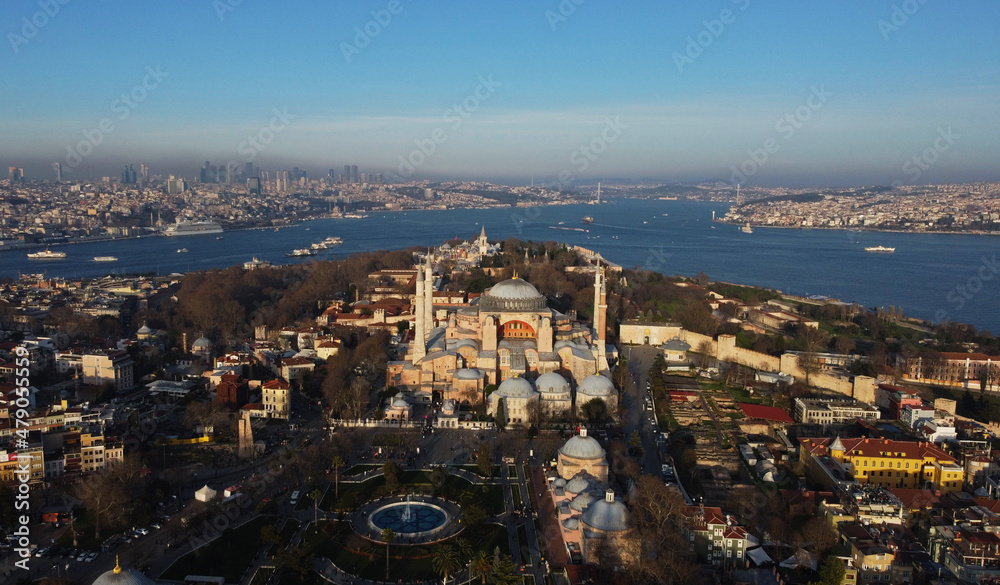 Aerial panoramic view of Byzantine-era Hagia Sophia after its conversion back into a mosque, during a blue sky sunny day in Istanbul, Turkey. Bosporus strait is seen in the background.