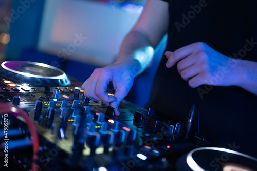 Dj mixing at party festival with light and smoke in background - Summer nightlife view of disco club inside.High quality photography.