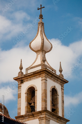 NO alto da torre da igreja tem-se a forma arquitetônica com a simbologia do sino.