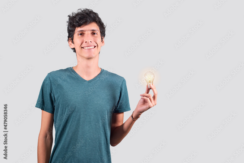Ideas and innovation, young latin guy holds a light bulb on. Ideas and innovation, young latin guy holds a light bulb on.
