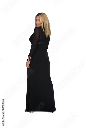rear view of a woman dressed in an elegant dreess looking at camera on white background