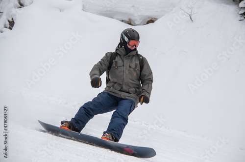 a man on a snowboard rides down the side of the mountain