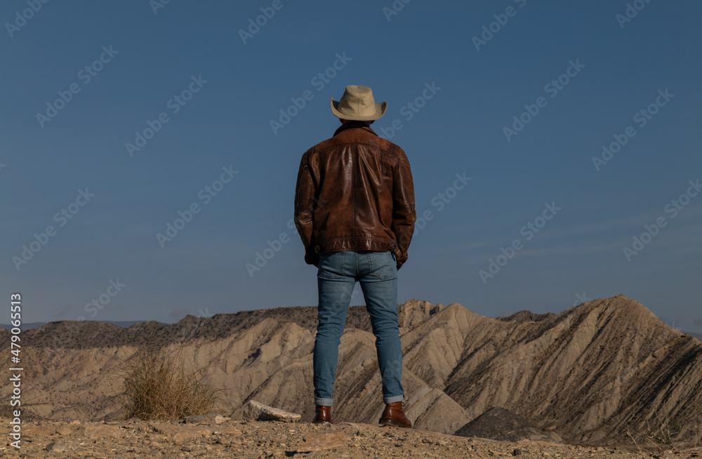 Rear view of adult man legs standing on cliff in Tabernas Desert, Almeria, Spain Rear view of adult man legs standing on cliff in Tabernas Desert, Almeria, Spain