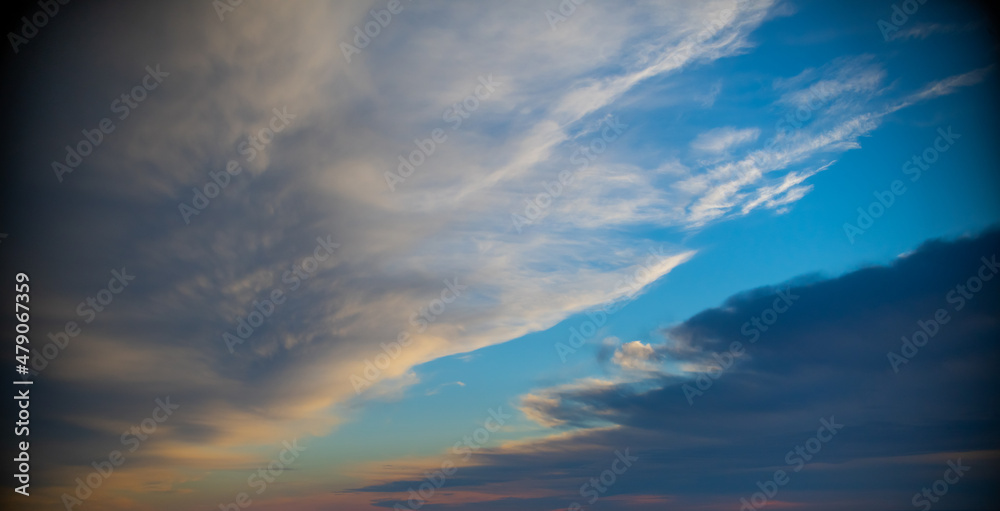 heavenly clouds in blue sky white and grey colors in clouds parted to reveal blue sky in heavens above layers fo puffy white clouds high above the horizon in day time horizontal format religious feel