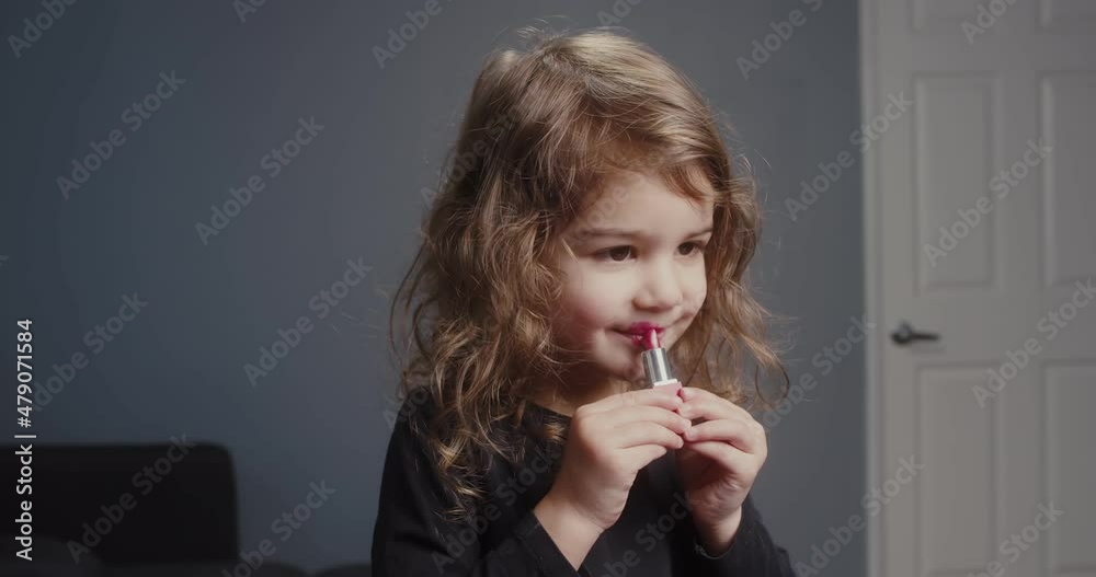 Cute toddler girl trying on lipstick for the first time. 4K footage. Cute toddler girl trying on lipstick for the first time. 4K footage.