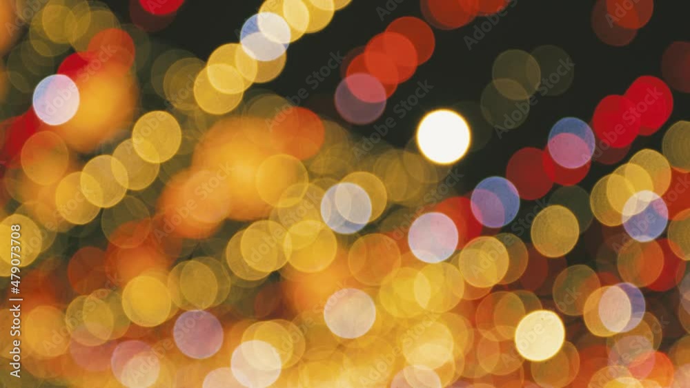 Beautiful holiday red, white and orange sparkling and glowing holiday lights shining at night. Abstract bright 4k stock video bokeh background