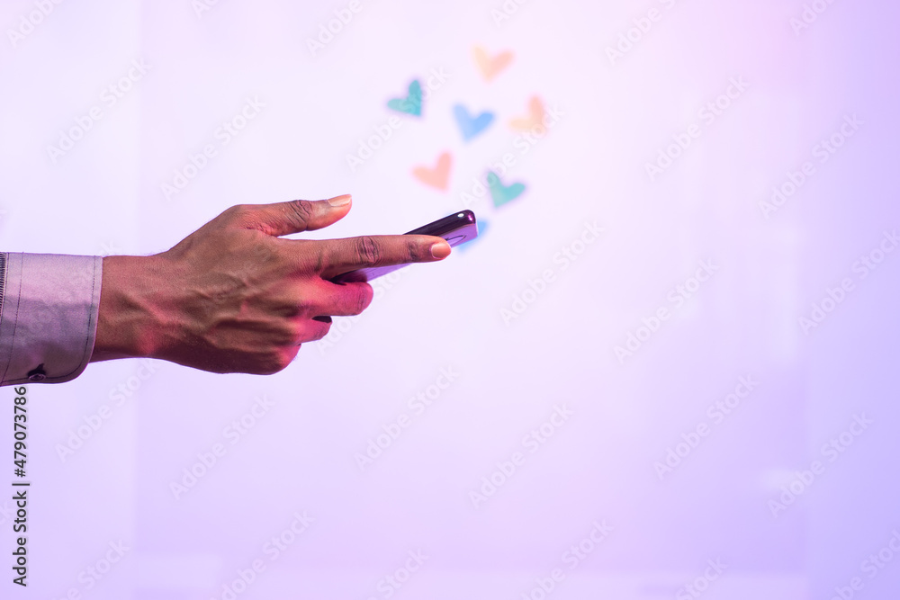 black person using his phone with love shapes floating on top