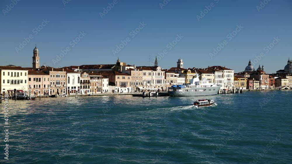 Venice, Italy - January 2022 - Traveling on the ferry that transports cars, along the Giudecca canal, among the historic buildings of the lagoon city Venice, Italy - January 2022 - Traveling on the ferry that transports cars, along the Giudecca canal, among the historic buildings of the lagoon city