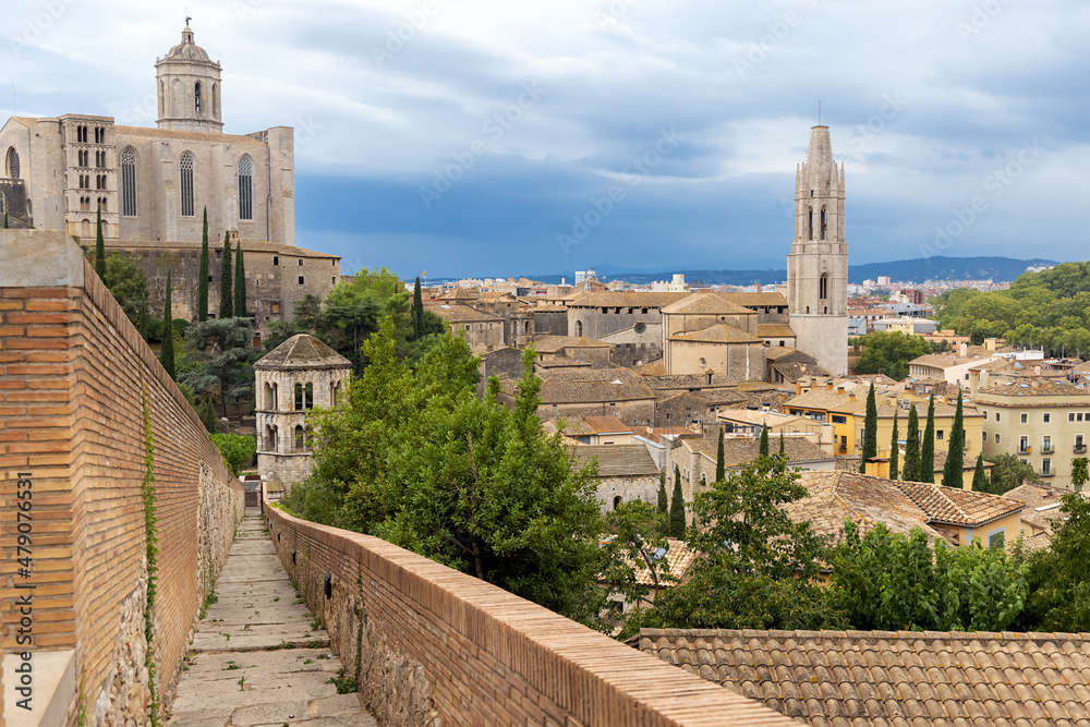 View from the protective wall on the medieval city of Girona with the Cathedral of St. Maria and the Church of St. Feliu. Girona, Catalonia, Spain.