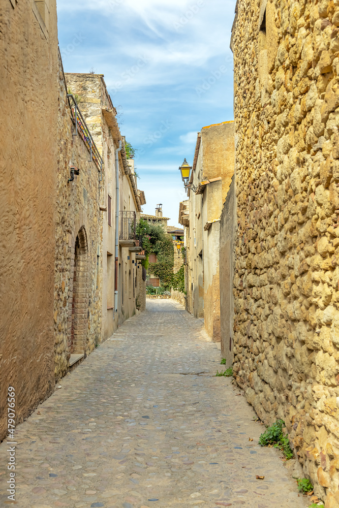 Begur, a narrow street with stone buildings, a street lamp in the old town of begur, catalonia, Girona, northeastern spain.