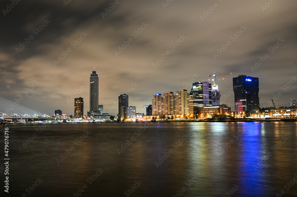Fototapeta premium City of Rotterdam by night. Panoramic view of skyscrapers and lights on buildings in town. Night skyline in Rotterdam, Netherlands.