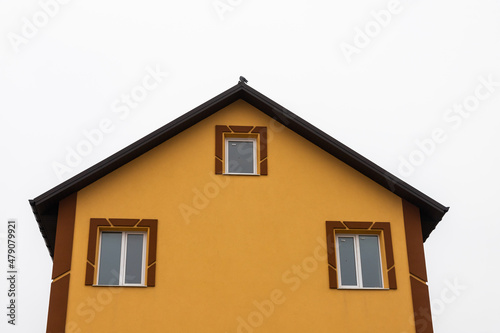 The roof of the house is made of red metal tiles  a beautiful large chimney