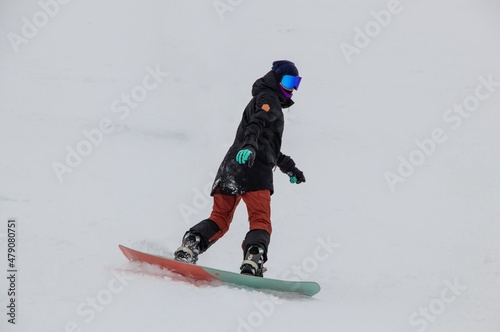 a girl on a snowboard rides down the side of the mountain