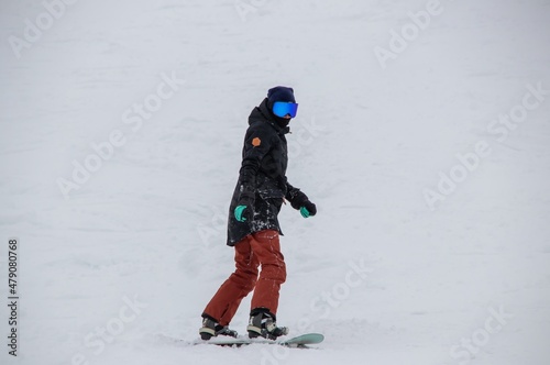 a girl on a snowboard rides down the side of the mountain