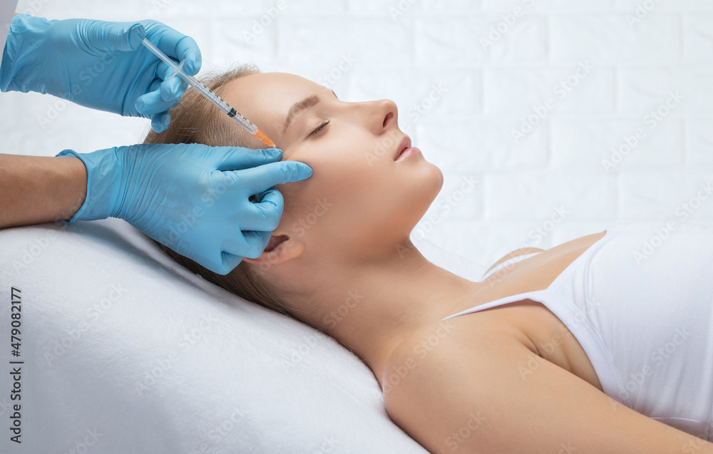 Cosmetologist makes rejuvenating anti wrinkle injections on the face of a beautiful woman. Female aesthetic cosmetology in a beauty salon. Cosmetologist makes rejuvenating anti wrinkle injections on the face of a beautiful woman. Female aesthetic cosmetology in a beauty salon.