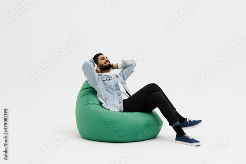 Tableau sur toile businessman relaxing on bean bag chair, isolated on white background