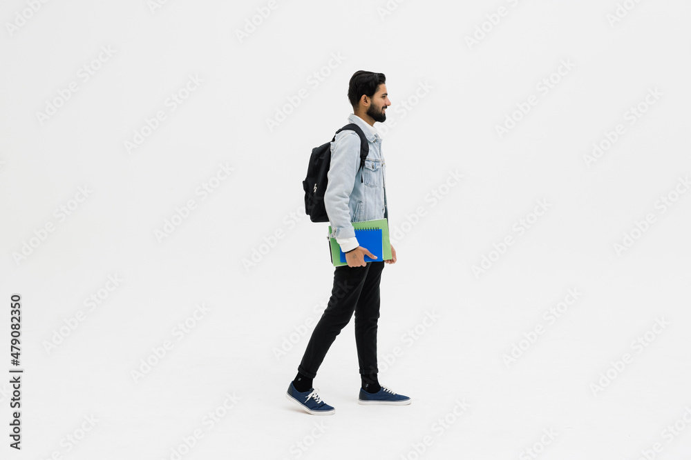 Smiling indian student standing with textbooks and backpack on white background Smiling indian student standing with textbooks and backpack on white background