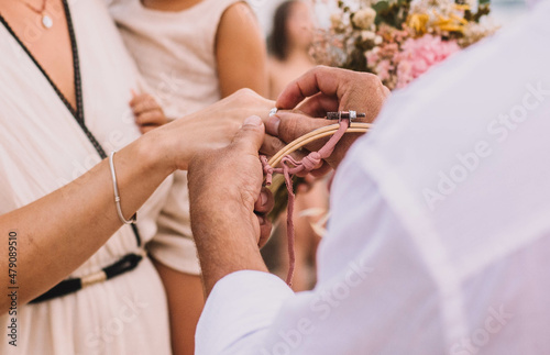 Novios poniendose los anillos en una boda en la playa photo